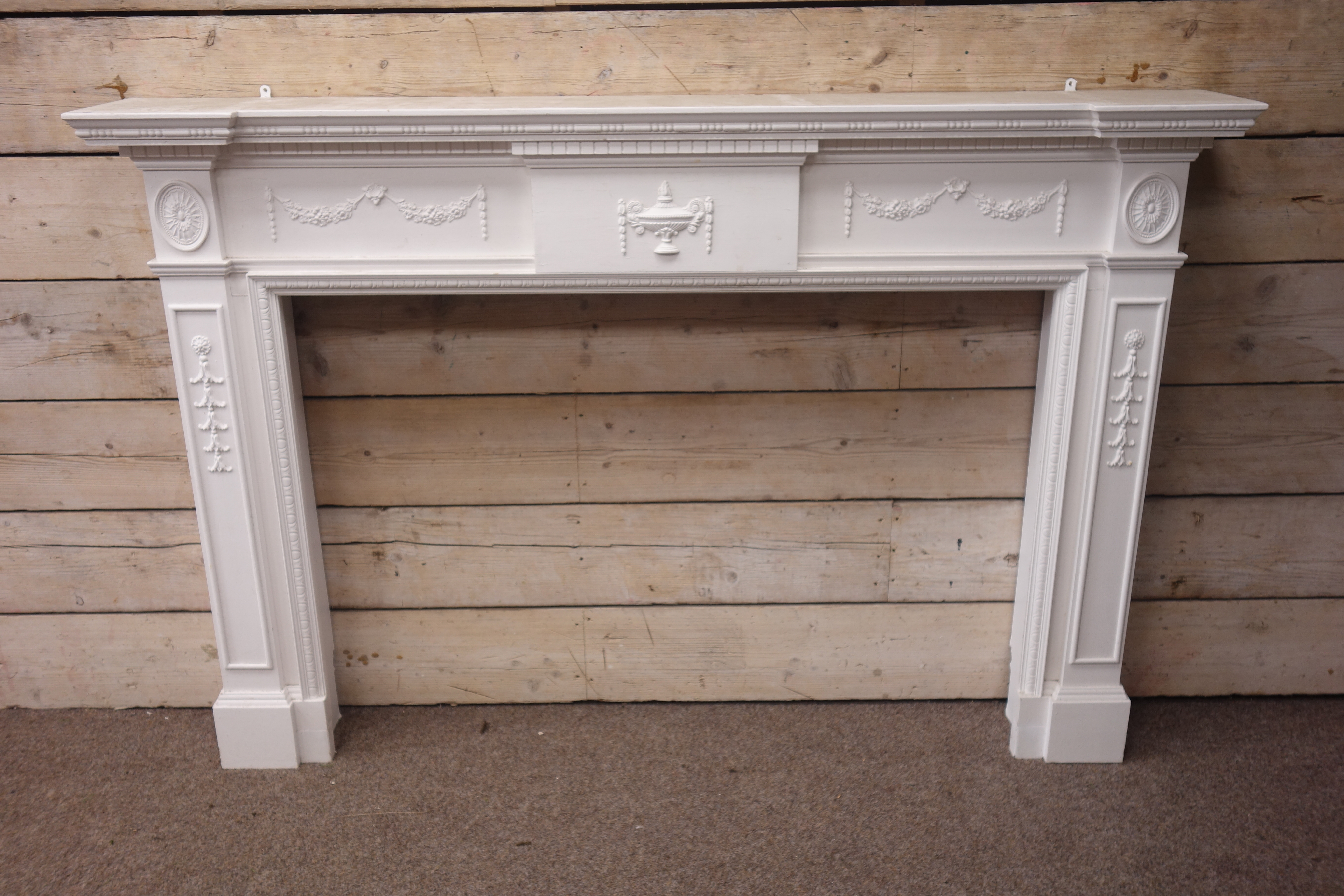 Large 20th century Adams style reverse breakfront fire surround, white painted wood,