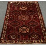 Persian red ground rug, geometric pattern field, repeating border,