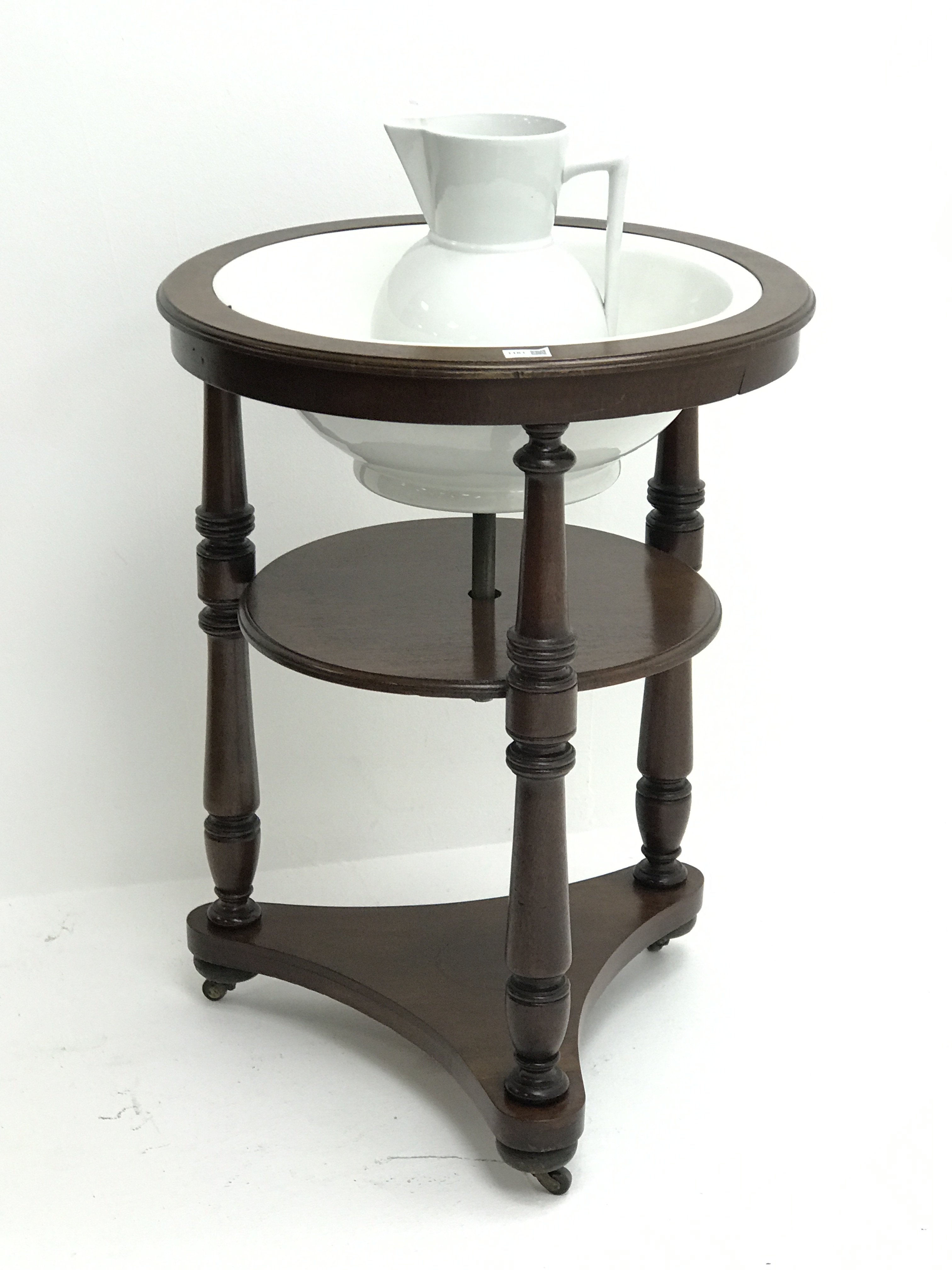 Early 19th century circular mahogany two tier washstand with ceramic bowl and jug,