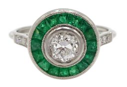 Platinum old cut diamond and calibre cut emerald target ring, with diamond set shoulders,