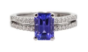 18ct white gold emerald cut tanzanite ring, the shank with two rows of round brilliant cut diamonds,