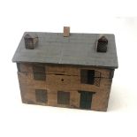 A reproduction Victorian hinged box in the form of a house with painted and moulded decoration,