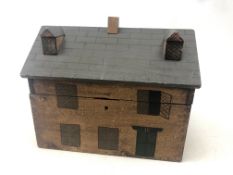 A reproduction Victorian hinged box in the form of a house with painted and moulded decoration,