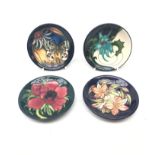Four Moorcroft pin dishes, each of circular form, decorated in the Clematis, Thistle,
