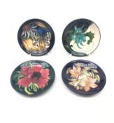 Four Moorcroft pin dishes, each of circular form, decorated in the Clematis, Thistle,