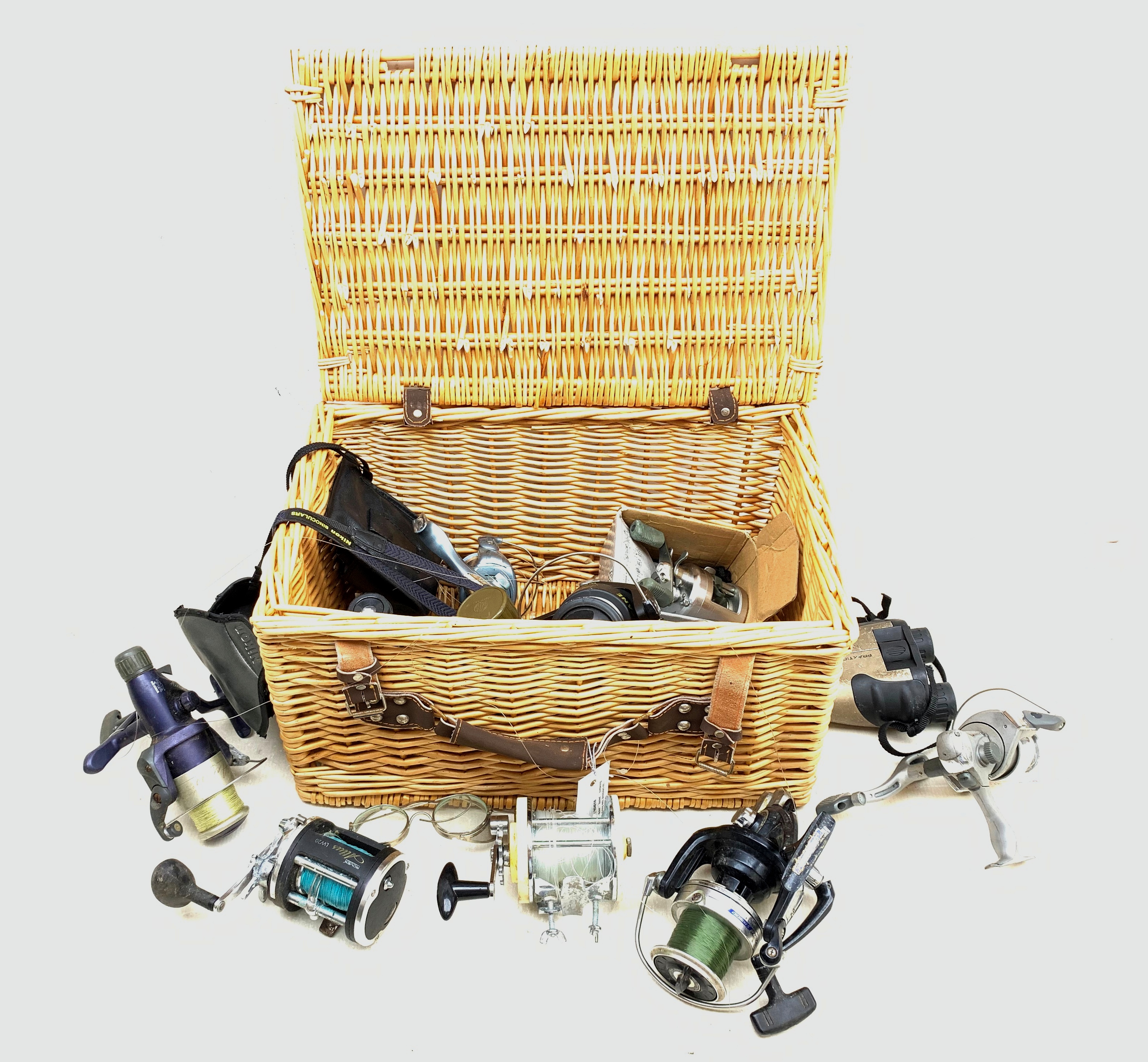 Wicker basket containing various fishing reels including Masterline 'Toothy Critter',