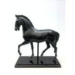 A large bronze style model of a horse, raised upon a black rectangular base, H59cm.