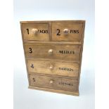 An Anchor Mills cotton reel chest, with two short over three long drawers, upon a plinth base,