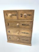 An Anchor Mills cotton reel chest, with two short over three long drawers, upon a plinth base,