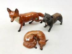 A Beswick figurine modelled as a fox in recumbent pose, with impressed and printed marks beneath,