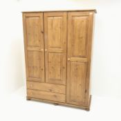 Pine triple combination wardrobe, three doors above two drawers on bun feet, W1325cm, H181cm,
