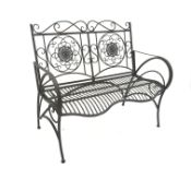 Wrought metal rustic grey garden bench with curved arms and shaped back,