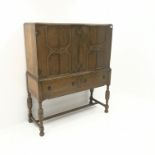 Early 20th century oak cocktail cabinet, four doors enclosing shelves above two drawers,