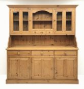 Traditional waxed pine dresser, top section fitted with two glazed display cabinets,