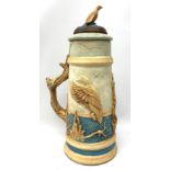 A large earthenware stein, decorated with a moulded continuous band of game birds, with confirming