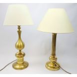 Two large gilt metal table lamps, each with accompanying cream fabric shade, largest H77cm high.