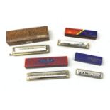 A group of four cased Harmonicas, comprising a Hohner 64 Chromonica, a Hohner Echo, a Hohner Song Ba