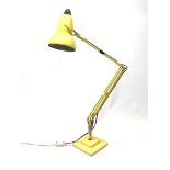 A yellow Herbert Terry & Sons Ltd Anglepoise lamp, on a square stepped base.