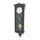 Early 20th century ebonised Vienna type wall clock, shaped pediment over arch glazed door, circular