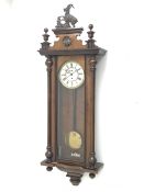 Late 19th century Vienna type wall clock in walnut case, figural pediment above glazed door with ha