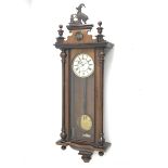 Late 19th century Vienna type wall clock in walnut case, figural pediment above glazed door with ha