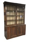 Early 19th century stained pine bookcase on cupboard, fitted with two astragal glazed doors above tw