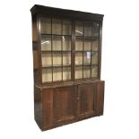 Early 19th century stained pine bookcase on cupboard, fitted with two astragal glazed doors above tw