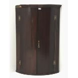 George III mahogany bow corner cabinet, two doors enclosing three shelves, W74cm, H107cm