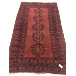 Afghan red ground rug, field decorated with Guls, repeating border, 204cm x 112cm