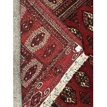 Turkman Tekke Bokhara red ground rug, the field and border decorated with guls, 177cm x 213cm