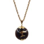 Gold mounted kukui nut pendant, on gold chain with barrel clasp stamped 9c