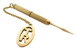 Gold engine turned toothpick hallmarked 9ct, with gold 'TR' fob and chain stamped 9ct