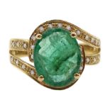 Gold oval emerald ring with diamond swirl surround and shank, stamped 14K