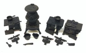 Three miniature cast iron salesman sample stoves, together with a miniature cast iron pot belly stov