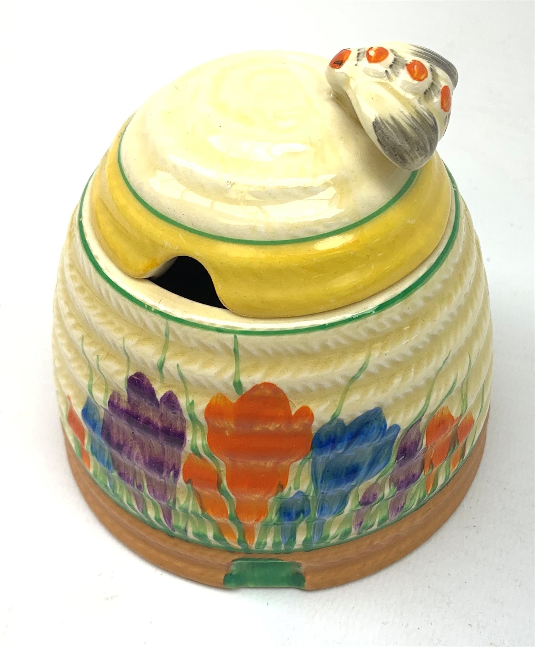 A Clarice Cliff Bizarre honey pot, of domed form with bee finial to the removable cover, decorated i