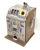 A one arm bandit fruit slot machine, the oak case with cast metal front and top with polychrome deta
