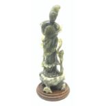 Chinese Green stone carved figure of a lady wearing flowing robes and a fan on circular plinth, H33c
