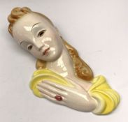 A 20th century American Goldscheider Art Deco wall mask, modelled as a blonde haired female in yello