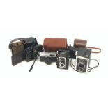 A group of cameras, to include an Olympus Trip 35, a Vest Pocket Kodak Model B, a Minolta H-Matic S,