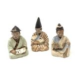 Three Japanese earthenware nodding head figures, each modelled as a seated male, tallest H13.5cm.