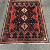 Persian style red and blue ground rug, three central diamonds, repeating border, 220cm x 165cm