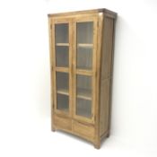 Light oak illuminated bookcase display cabinet, two glazed doors enclosing three shelves above two d