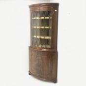 20th century figured mahogany bow front corner cabinet, projecting cornice, dentil frieze, single do