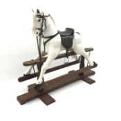 20th century carved and painted wood rocking horse, leather saddle and reins, stirrups, trestle base