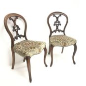 Pair Victorian walnut bedroom chairs with pierced and carved balloon backs, upholstered serpentine s