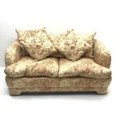 Two seat sofa upholstered in a cream ground floral pattern fabric (W168cm)