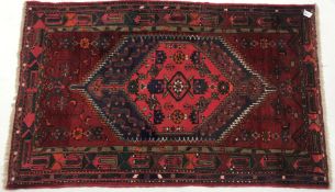 Afghan hand knotted red ground rug, diamond centre with geometric pattern, 195cm x 122cm