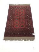 Persian style red ground rug, patterned field, repeating border, 135cm x 86cm