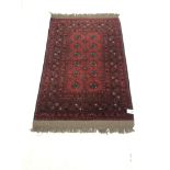 Persian style red ground rug, patterned field, repeating border, 135cm x 86cm