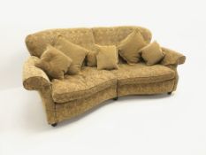 Three seat curved traditional sofa, scrolled arms, upholstered in a gold ground fabric with a floral